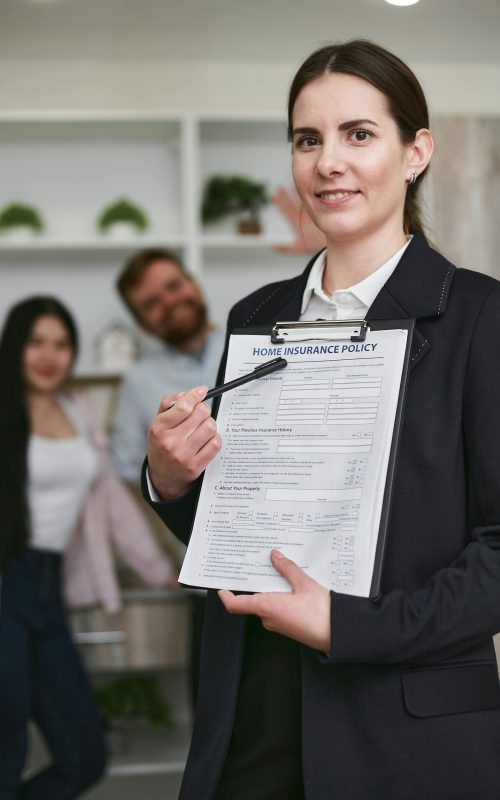 Confident businesswoman presenting a home insurance policy indoors to potential clients.